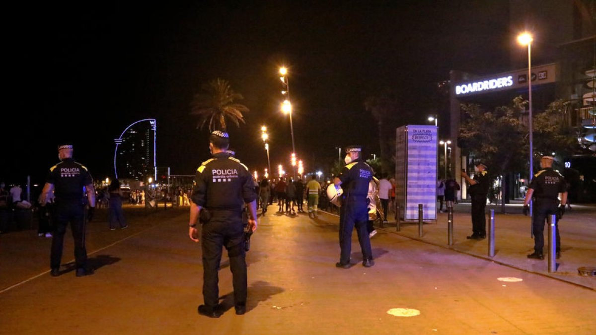 Policías desalojando a personas en la playa de Barcelona. 