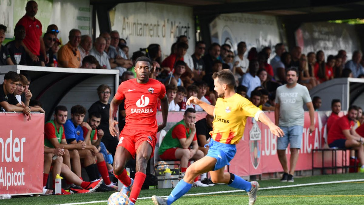 Un jugador del Alpicat trata de avanzar ante la presión de un jugador rival.