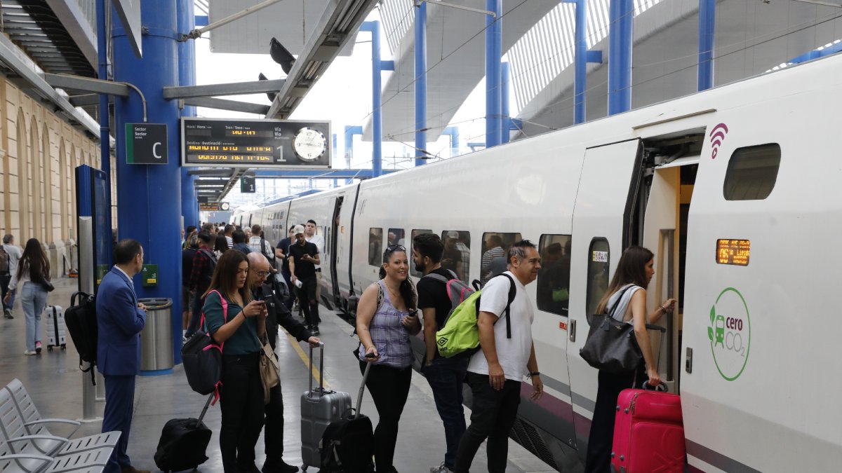 Diverses persones pujant a un tren AVE aquest divendres a l’estació de Lleida.