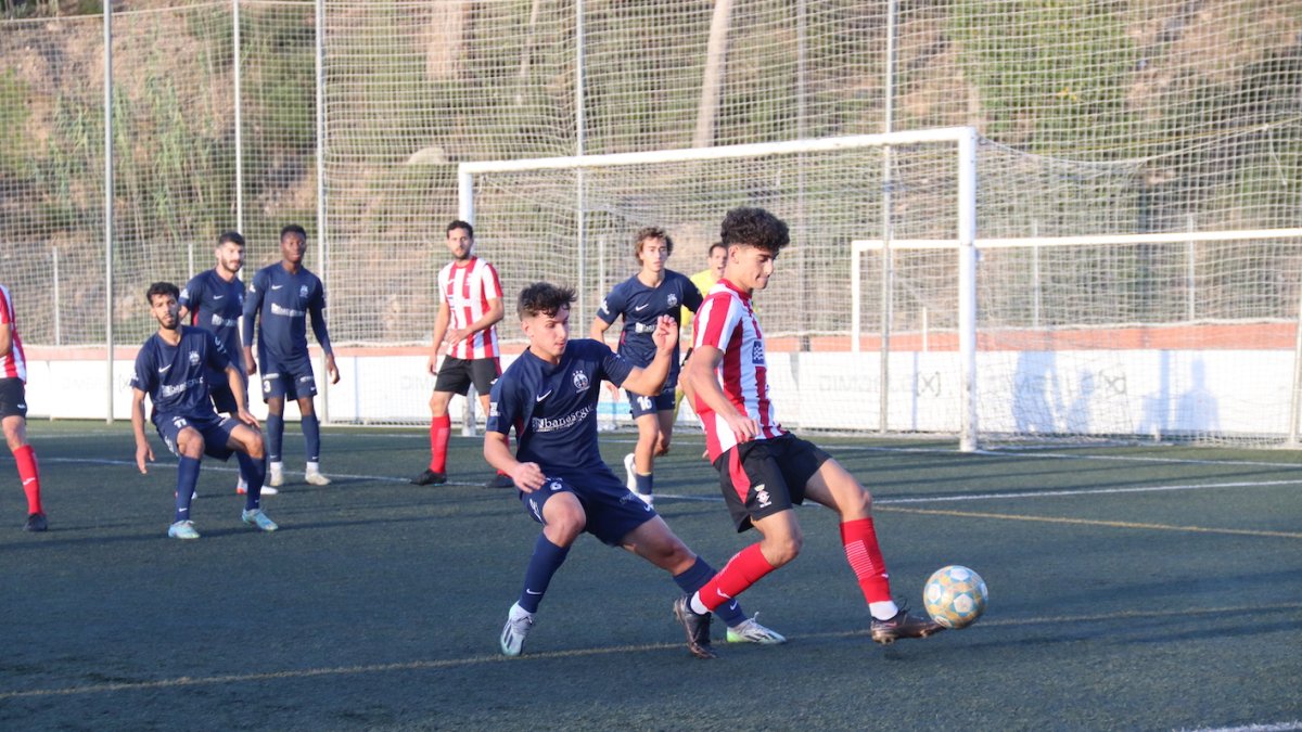 Un jugador de l’Atlètic Lleida prova de prendre el control de la pilota a un rival.