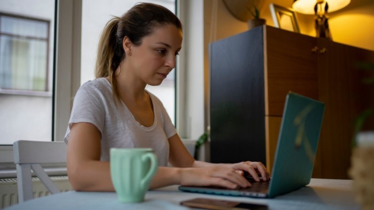 Una dona teletreballant a casa amb l’ordinador.