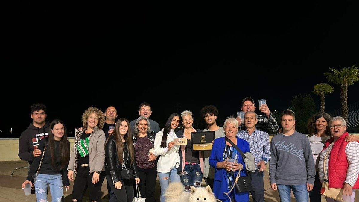 L’equip del local, amics, familiars i mascota, celebrant la victòria a la plaça de la Llotja.