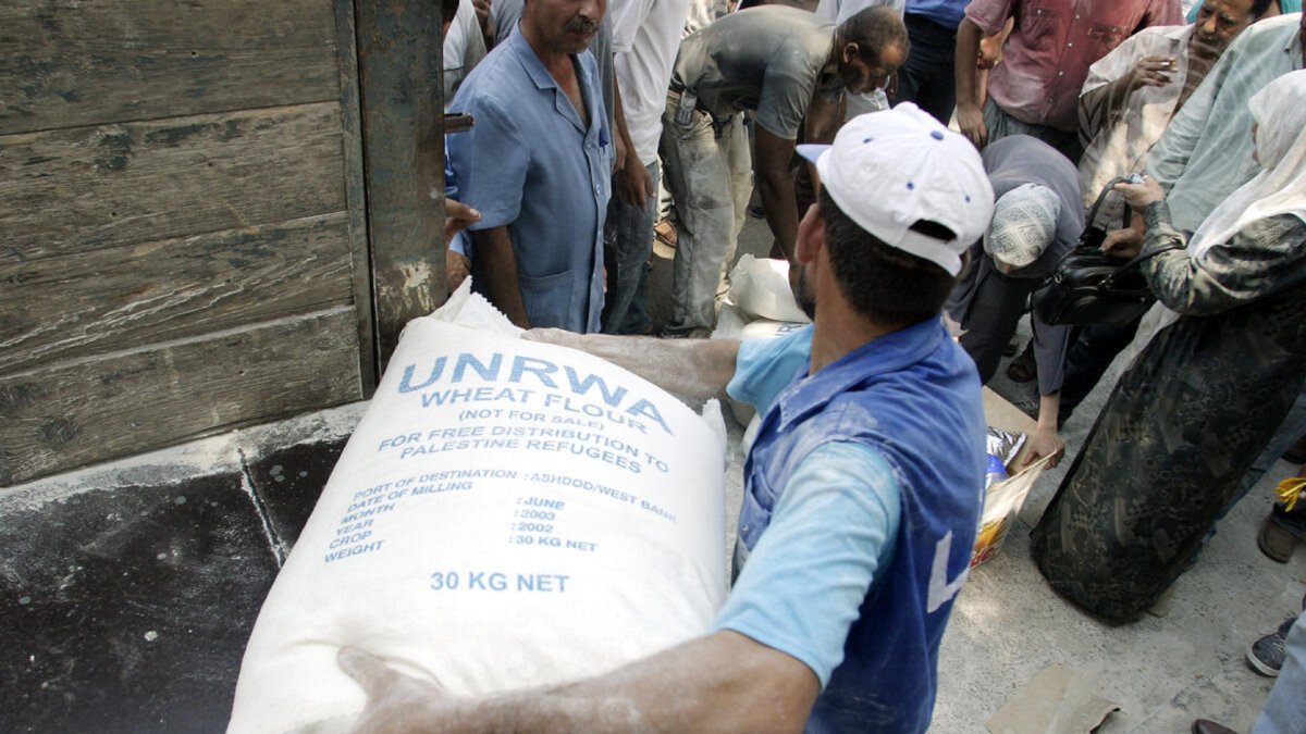Un treballador de l’Agència de l’ONU per als Refugiats Palestins descarregant farina a Gaza.