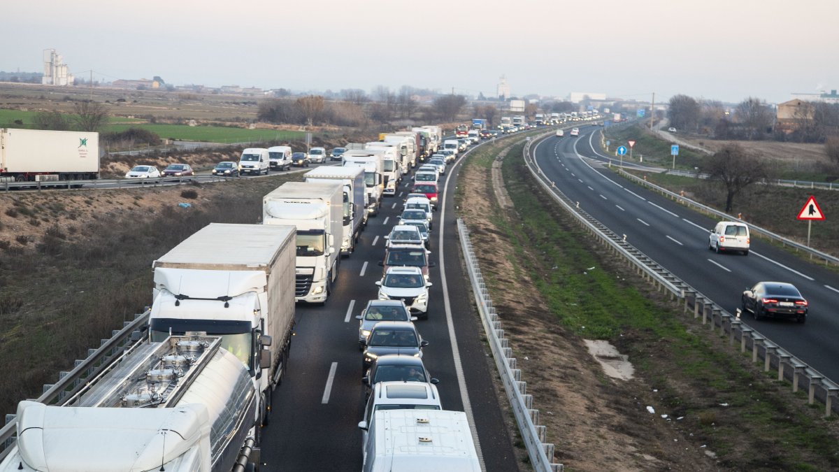 Imatge del tractor bolcat ahir a Castelldans. A la dreta, llargues cues a la tarda a l’autovia per un accident a Castellnou de Seana.