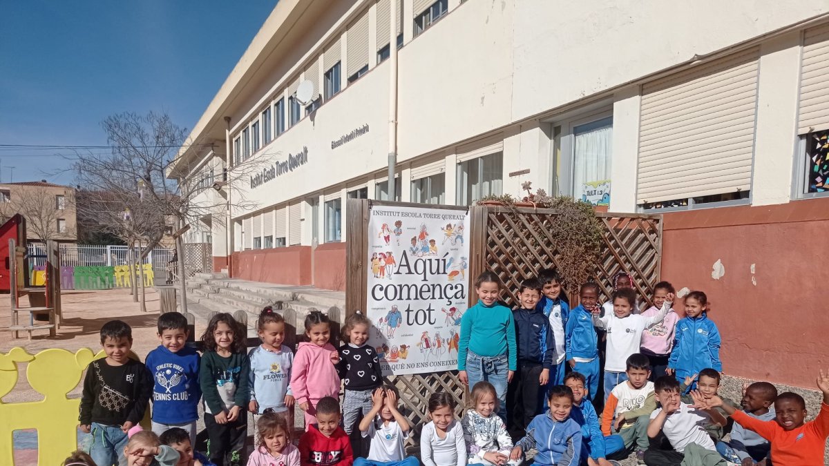 Alumnes de l’institut escola Torre Queralt, del Secà, a l’exterior amb la pancarta de la campanya i a l’interior d’una aula.