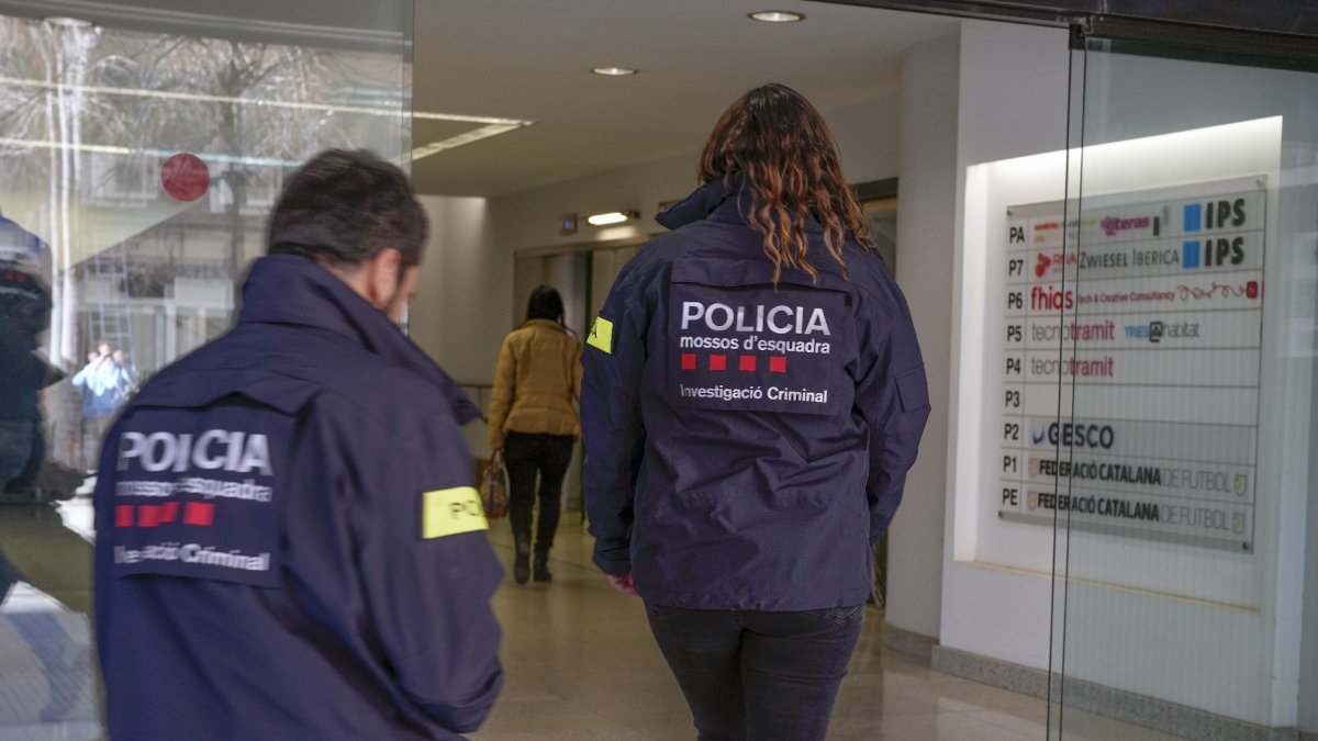 Dos agents dels Mossos entrant ahir a la seu de la Federació Catalana de Futbol a Barcelona.