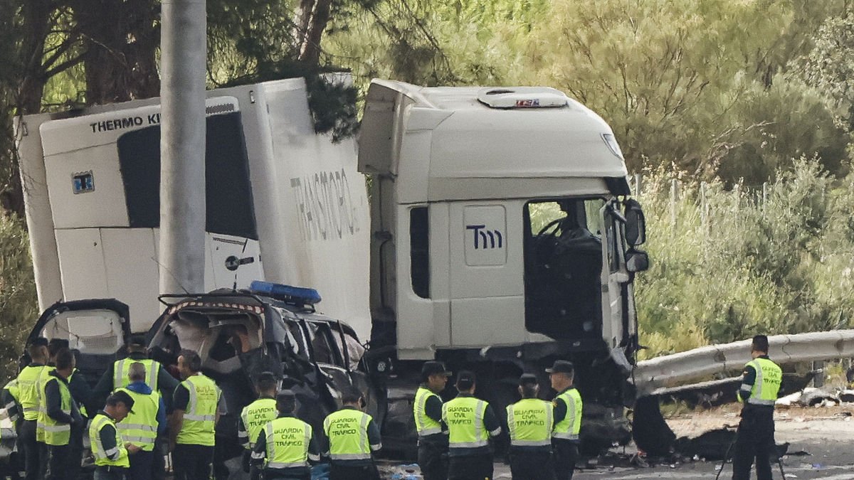 Guàrdies civils al lloc de l’accident, amb el camió que va atropellar diversos turismes, entre aquests un cotxe patrulla, encara creuat a la via.