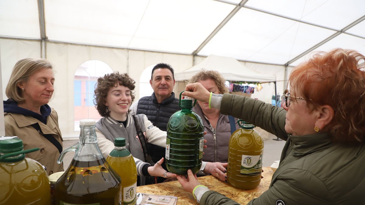 Visitants de la Fira de Vinaixa comprant una garrafa d’oli de 5 litres al recinte.