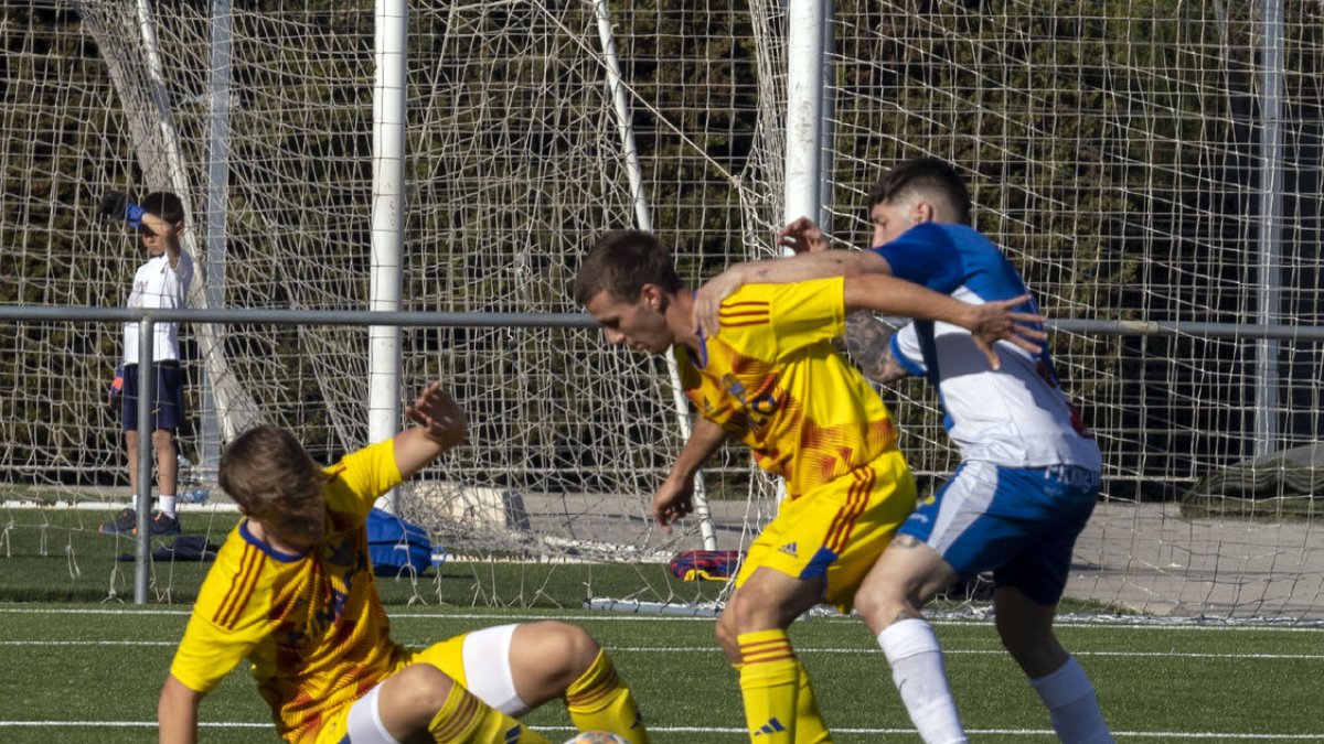 Dos jugadors del Lleida B protegeixen l’esfèric davant la pressió d’un rival.