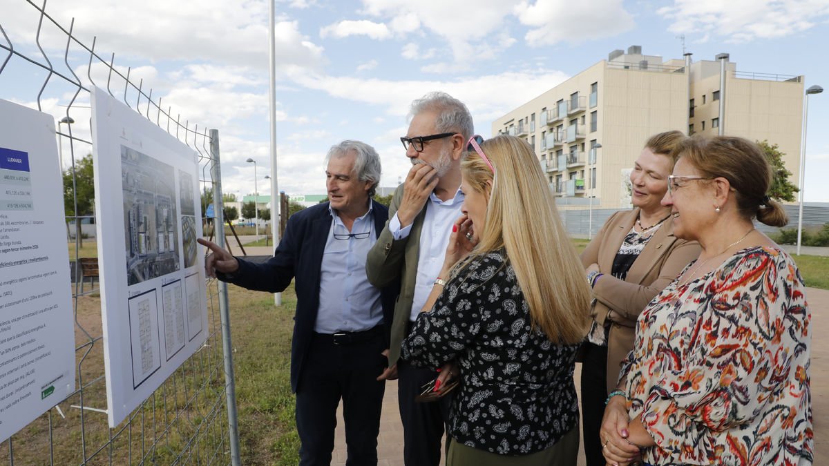 Fèlix Larrosa i Albert Simó mostren els plans dels pisos a la presidenta veïnal de Magraners.