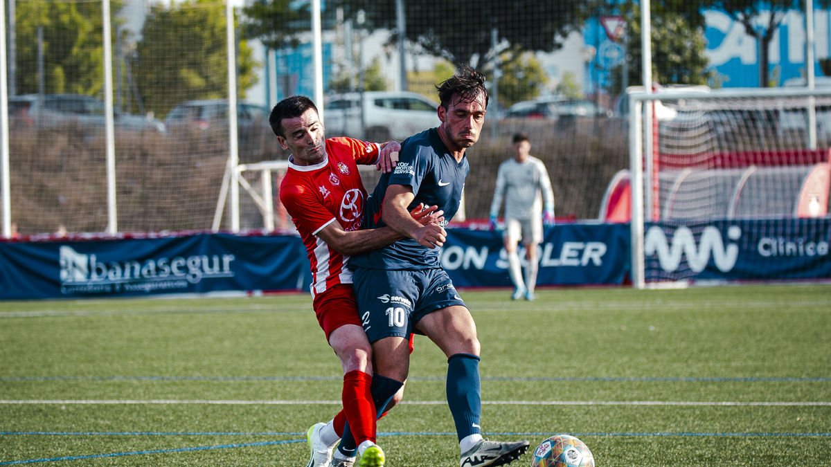 Peke disputant una pilota amb un jugador del Vic.