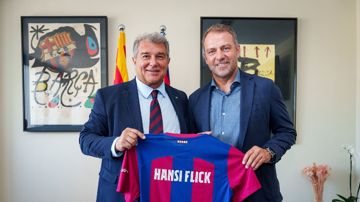 Hansi Flick posa amb Joan Laporta subjectant una samarreta del Barça amb el seu nom imprès.