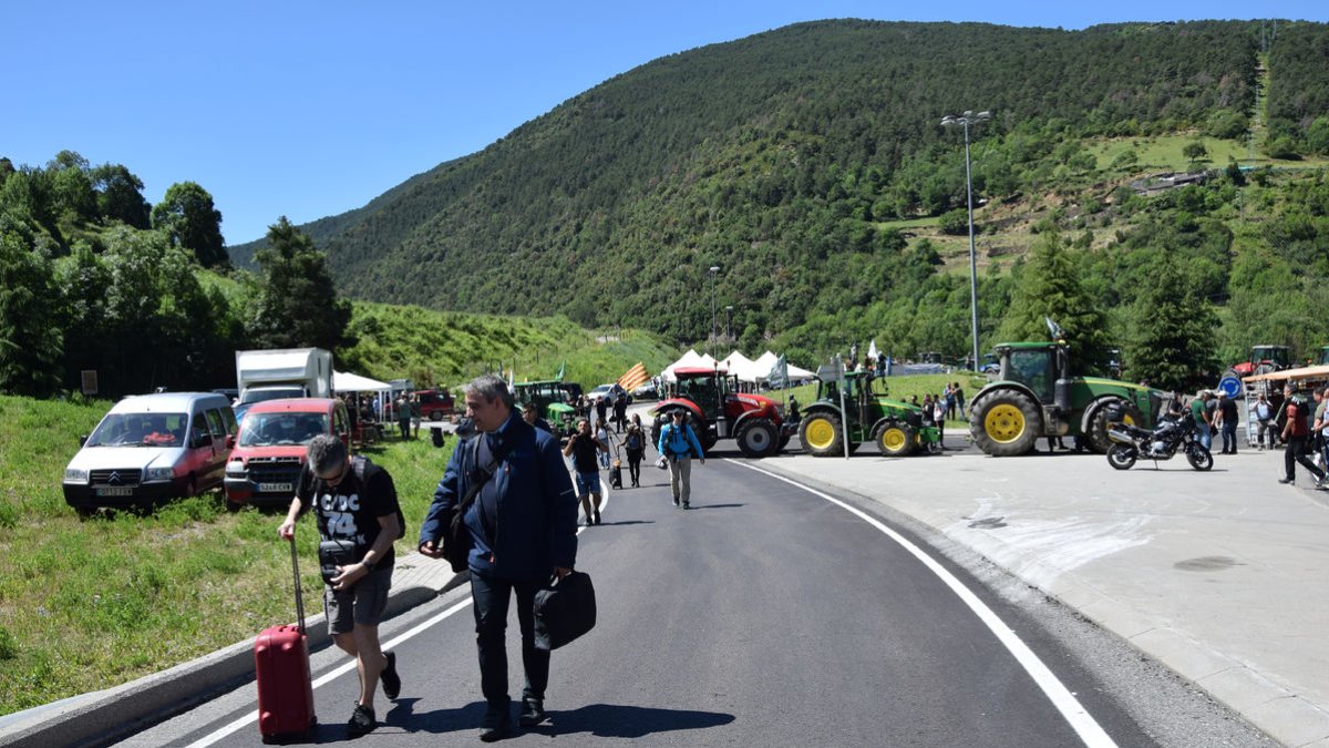 Alguns viatgers van creuar caminant amb les maletes.