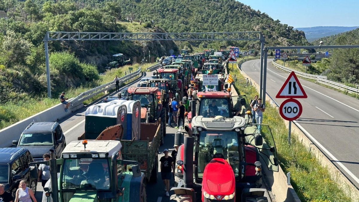 Una llarga columna de tractors tallant ahir l’AP-7 a la frontera amb França a la Jonquera.