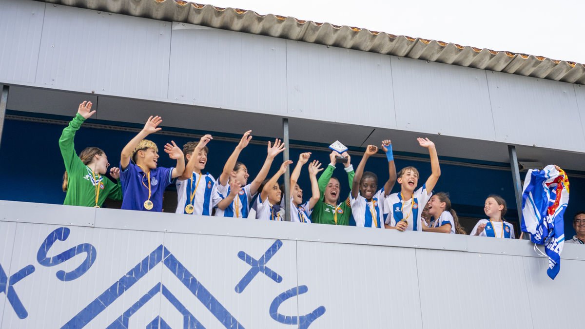 Les jugadores de l’Espanyol aixequen el trofeu de vencedores del Memorial Dani Rodrigo a la llotja del Recasens.