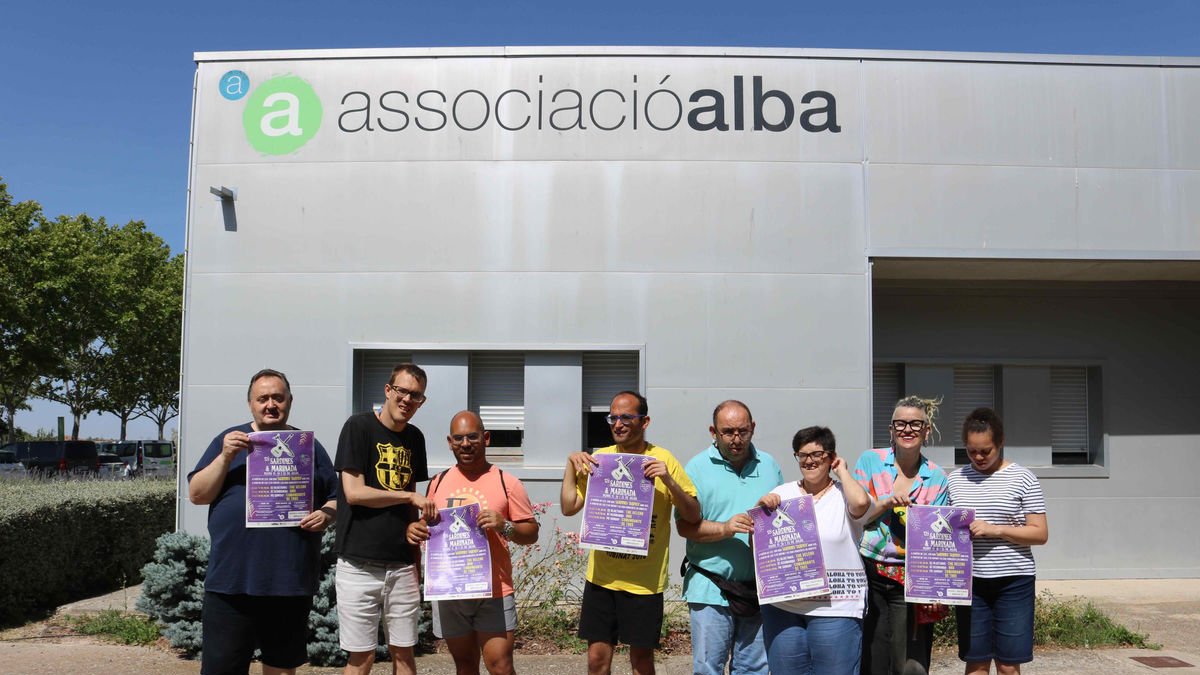 Voluntaris de l’Associació Alba de Tàrrega amb el cartell del festival Sardines & Marinada.