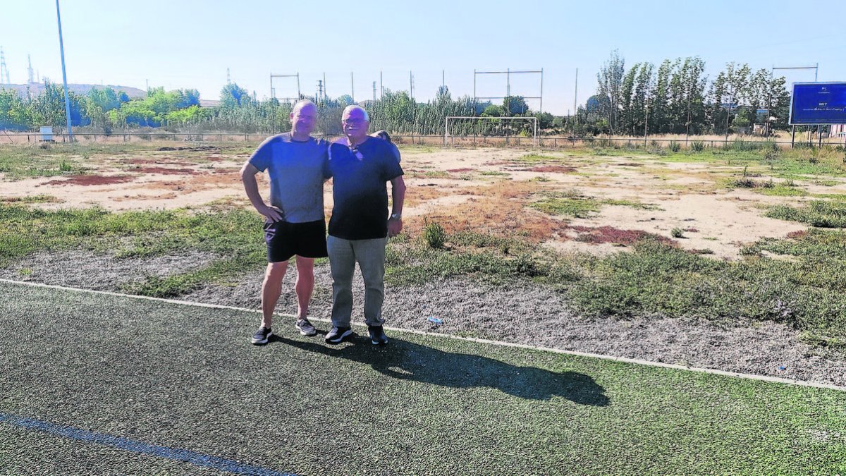 Bartolo Ayora i el secretari Pedro Pino, davant del terreny on es col·locarà gespa artificial.