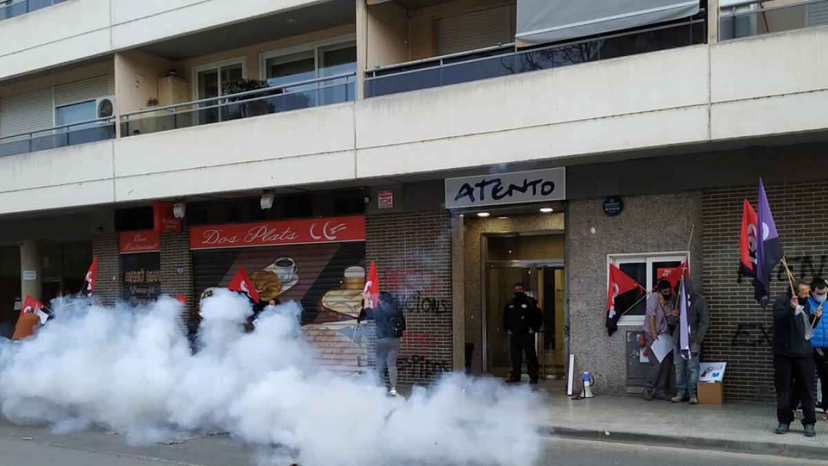 Bomba de fum davant del centre d’Atento a Lleida en una manifestació el 2021 per 13 acomiadaments.