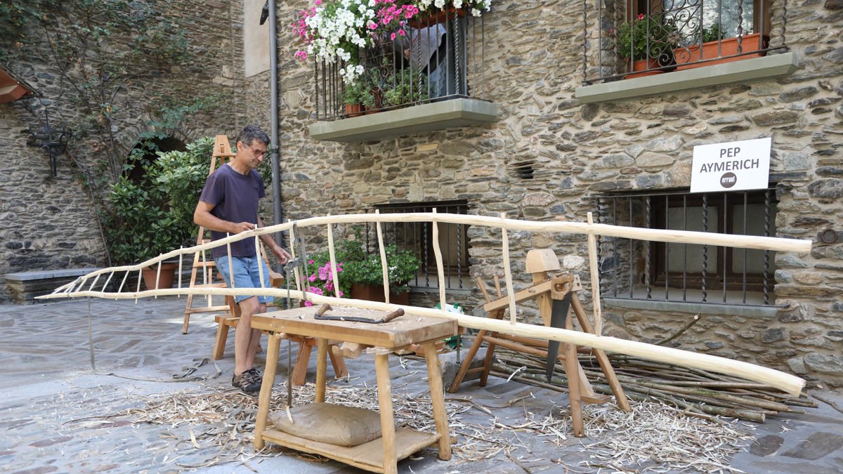 Pep Aymerich creant una escultura de fusta, un dels tallers artístics als carrers de Llavorsí.