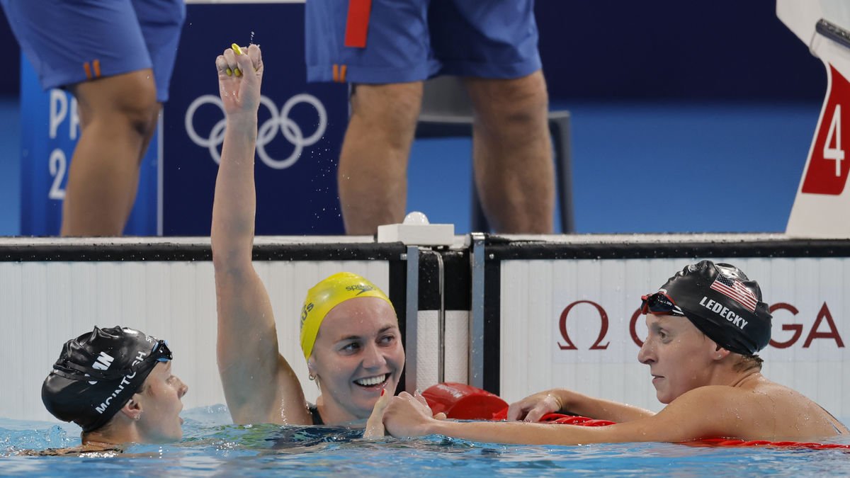 La nadadora australiana Ariarne Titmus celebra la victòria flanquejada per McIntosh i Ledecky.