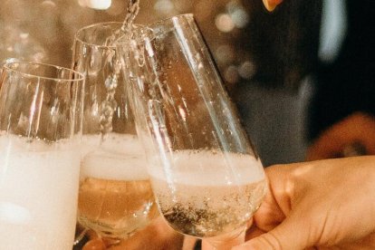 Personas sirviéndose una copa de cava