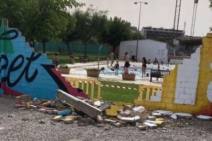 Part del mur de les piscines del poliesportiu de Balaguer, enderrocat i precintat.