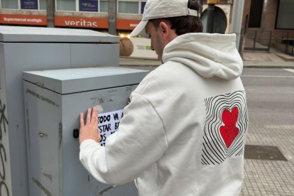 Jordi Villegas colgando uno de sus carteles en la calle