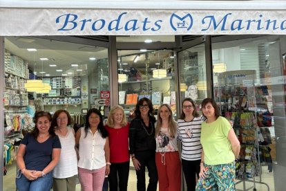 Treballadores de Brodats Marina, Maria Alba Roca i Marina Monsó, a la porta de la botiga, situada al carrer de les Corts Catalanes.