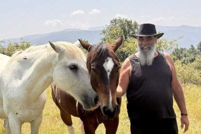 Pere Cases, amb dos dels cavalls retirats que cuida al seu refugi de Montcortès. - MARTA LLUVICH/ACN