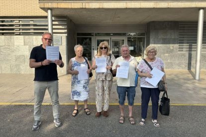 Familiars d’usuaris davant la residència, que compta amb 96 places geriàtriques i 30 de centre de dia, amb les queixes presentades. - MARC CARBONELL