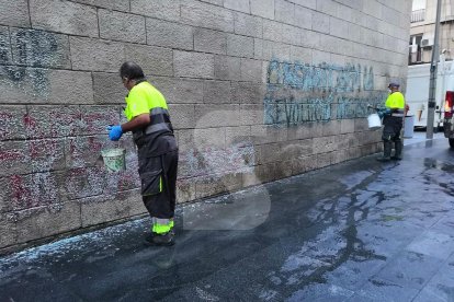 Operaris netejant la pintada que va aparèixer a la façana de l'IEI i on finalment va caldre aplicar tècniques especials per suprimir-la d'aquesta joia del gòtic civil.