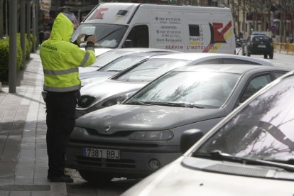 Imatge d’arxiu d’un vigilant de zona blava registrant fotogràficament una infracció.