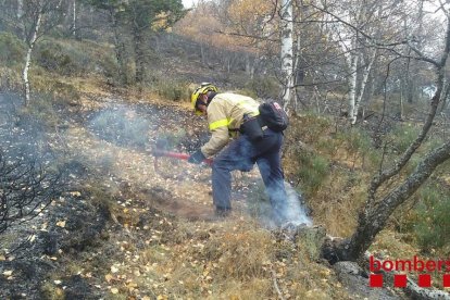 Un efectiu del Bombers treballant en l'incendi amb eines manuals.