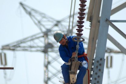 Un treballador en una línia elèctrica