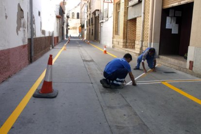 Treballadors de Soses i Alcarràs repintant vies urbanes.