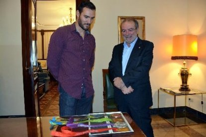 Saül Craviotto i Joan Reñé, ahir a la Diputació, observen les quatre medalles que atresora el palista.