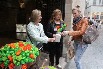 Una ciutadana col·labora, ahir, amb la iniciativa Una Flor per a un Projecte.