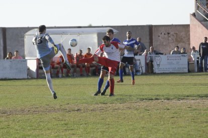 El porter visitant, Barcons, disputa la pilota amb un jugador del Linyola en una acció del partit.