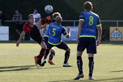 Un jugador de l’EFAC intenta controlar la pilota davant la pressió de dos futbolistes de l’Igualada.