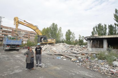 Miembros de la familia desalojada y los trabajos de derrumbe.