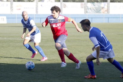 Carlos Martínez, que va entrar a la segona meitat, porta la pilota davant de la pressió de dos jugadors del Morell.