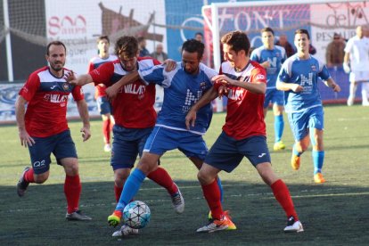 Dos jugadors del Balaguer pressionen per prendre la pilota a un futbolista del Vista Alegre.