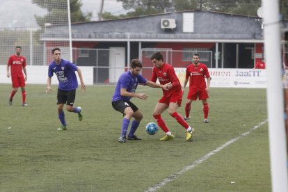 Un jugador de l’Alpicat i un altre del Jesús i Maria es disputen una pilota dividida.