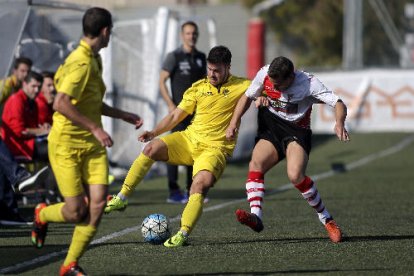 Un jugador de l’EFAC intenta controlar la pilota davant de l’oposició d’un rival.