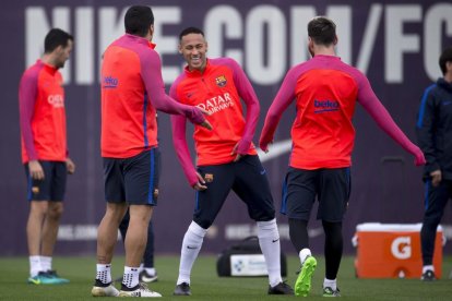 Neymar sonríe ayer en el entrenamiento frente a Luis Suárez y Messi.