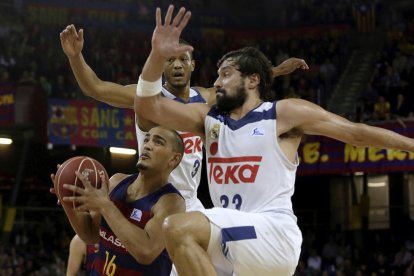 El azulgrana Stefan Peno intenta superar bajo la canasta a Sergio Llull y Anthony Randolph. 