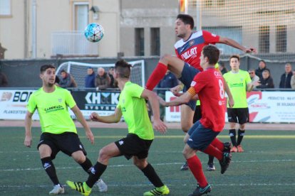 Pau Solanes despeja el balón ante la atenta mirada de dos jugadores del Viladecans. 