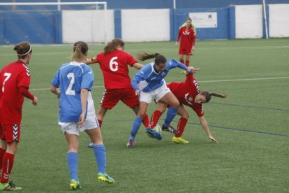 Una jugadora del AEM trata de salir de la presión de dos futbolistas rivales. 