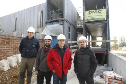 Los constructores, promotores y el arquitecto, delante de los contenedores que foman la estructura de la casa de Ciutat Jardí.