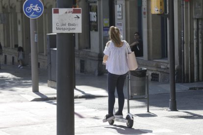 Una jove circula amb un patinet elèctric per rambla d’Aragó pel carril bici, ahir.